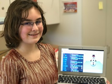 Alexandra Wyatt holds up a laptop with her snowman design.