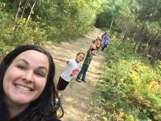 Picture of smiling Mrs. Walker and her first grade students in the China forest.